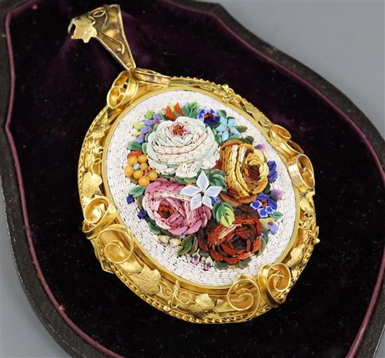A Victorian micro-mosaic oval pendant depicting roses and mixed flowers, with ornate frame and hinged locket back 55mm.